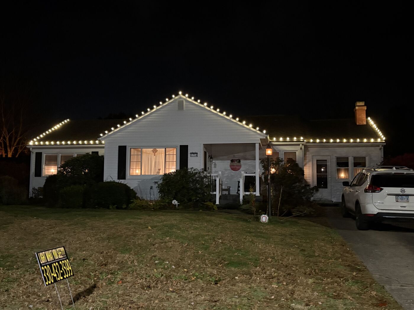Warm white holiday lighting along a ranch home's roofline