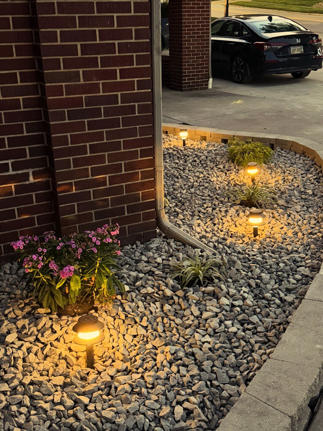 Landscape lighting and rock bed install along home foundation